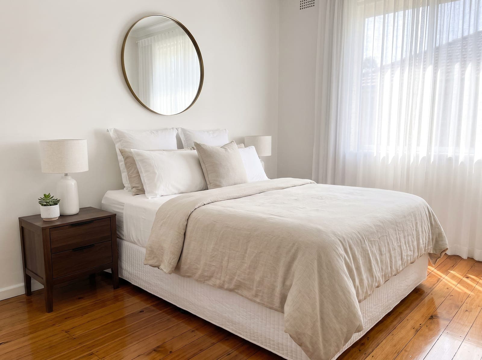 Clean white bedroom with bright sunlight